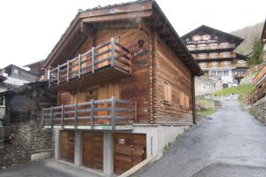 a wooden building with a balcony on the side of it at Chalet Renu in Saas-Fee