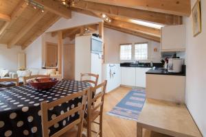 a kitchen and living room with a table and chairs at Chalet Renu in Saas-Fee