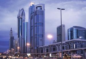 un profilo della città con grattacieli in una città di notte di Carlton Downtown Hotel a Dubai