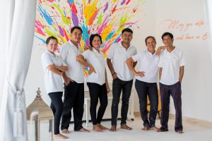 a group of people standing in front of a painting at Nirvana Villa & Boutique Hôtel in Taling Ngam Beach