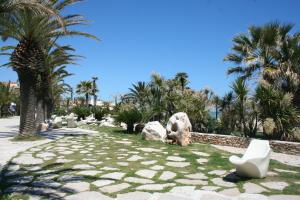 a park with palm trees and a white toilet at Appartamenti Vacanza Mare in San Benedetto del Tronto