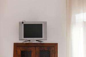 una televisione seduta sopra un mobile in legno di Monolocale finemente ristrutturato a Ostuni