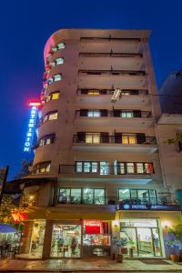 a tall apartment building with a lit up sign at Artemision in Athens