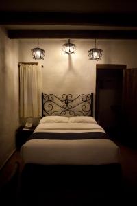 a bedroom with a large bed with lights above it at Hotel Casa Índigo in San Cristóbal de Las Casas