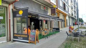 a restaurant with tables and chairs outside of a building at Albergue Ultreia in Arzúa