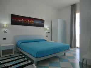 a bedroom with a bed with a blue bedspread at Mediterraneo Mare e Sole in Marina di Palma