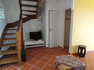sala de estar con escalera y TV en Villa Azur B, en Bouillante