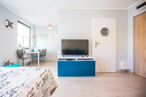 a bedroom with a blue cabinet with a tv in it at Apartament Kompas in Świnoujście