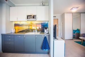 a kitchen with a sink and a microwave at Apartament Kompas in Świnoujście