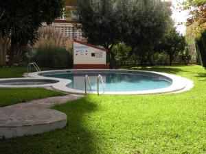 una piscina en la hierba con un cartel al lado en Gijon - Fincas Arena, en Benidorm