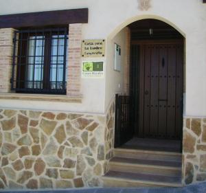 un edificio con puerta y pared de piedra en Casa Rural La Lumbre, en Enguídanos