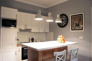 a kitchen with white cabinets and a white counter top at Apartments O la la in Zagreb