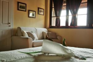 Agriturismo Bassanella في تريفيغليو: غرفة معيشة مع أريكة ونافذة