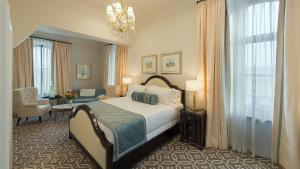 a bedroom with a bed and a table and a chair at Sydney Boutique Inn & Suites in Charlottetown