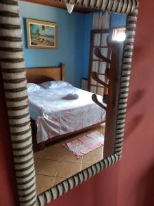 een slaapkamer met een bed en een spiegel bij Pousada Tony Montana in Praia de Araçatiba