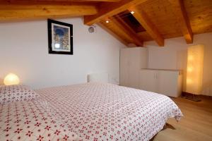 1 dormitorio con 1 cama con manta roja y blanca en B&B Sgonico, en Sgonico