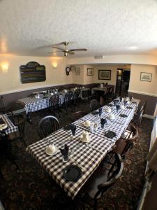 The Fox & Hounds Inn في West Burton: غرفة طعام مع طاولات وكراسي في مطعم