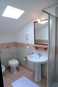 a bathroom with a sink and a toilet and a mirror at Appartamenti Greso in Custonaci