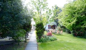 a garden with a walkway with chairs and flowers at Selkirk Arms Hotel in Kirkcudbright