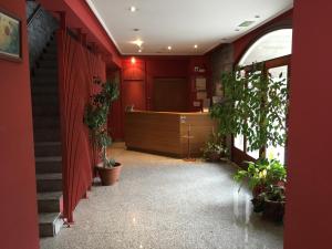um corredor com paredes vermelhas e vasos de plantas em Hotel Errekagain em Aracaldo