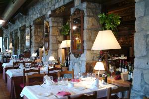 a dining room with tables and chairs with wine bottles at Hotel LLanos del Hospital in Benasque