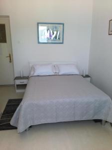 una camera da letto con un grande letto con lenzuola bianche di Rooms Katica a Korčula