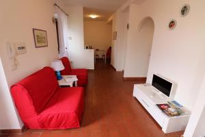 een woonkamer met twee rode stoelen en een televisie bij il Panorama di Vitorchiano in Vitorchiano