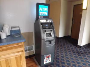 un bancomat in una camera d'albergo accanto a un bancone di Super 8 by Wyndham Sidney NY a Sidney