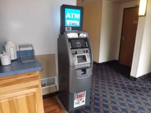 a atm machine in a hotel room next to a counter at Super 8 by Wyndham Sidney NY in Sidney