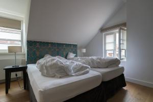 una camera da letto con due letti con lenzuola bianche di Hotel Schwarzwälder Hof a Friburgo in Brisgovia