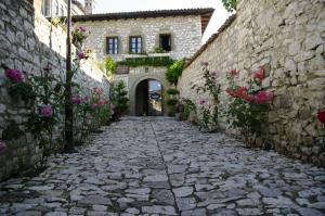 an alley with flowers on the side of a building at Hotel Klea in Berat