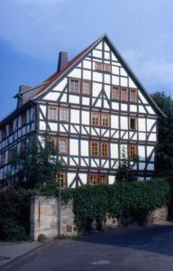 ein großes weißes und schwarzes Gebäude mit Fenstern in der Unterkunft Alte Pfarre Gudensberg in Gudensberg