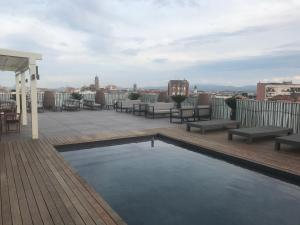 um terraço no último piso com uma piscina num edifício em Hotel Urpí em Sabadell