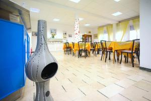 - une salle à manger avec une table, des chaises et un instrument dans l'établissement Hotel Majorca, à Cesenatico