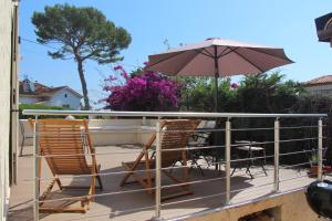 two chairs and an umbrella on a deck at B&B Bessy 10 in Antibes