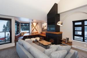 a living room with a couch and a fireplace at Gibbons Life Accommodations in Whistler