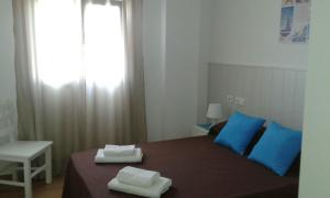 ネルハにあるApartamentos Tursolのベッドルーム1室(ベッド1台、タオル2枚付)