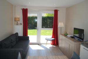 a living room with a couch and a sliding glass door at Gîte De Charme in Colmar