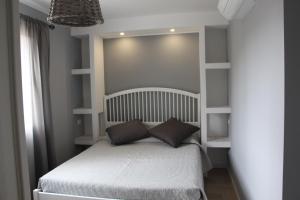a small bedroom with a white bed and shelves at B&B Bessy 10 in Antibes