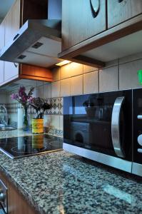a kitchen with a stove and a microwave at Apartamento Royal Centro de Ronda in Ronda