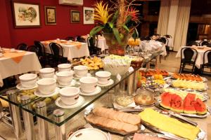 a buffet of food on a table in a restaurant at Itatiaia Hotel Passo Fundo in Passo Fundo