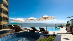 uma piscina com cadeiras e guarda-sóis num edifício em Majestic Palace Hotel em Florianópolis