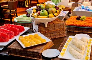 uma mesa coberta com pratos de frutas e produtos hortícolas em Majestic Palace Hotel em Florianópolis