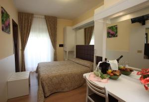 リド・ディ・イエゾロにあるPark Hotel Perù ***Sのベッド1台、テーブル(フルーツ付)が備わる客室です。