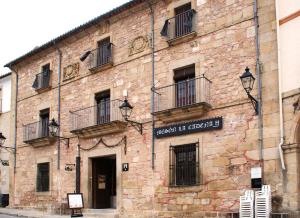 un viejo edificio de ladrillo con un cartel. en Hostal Meson la Cadena, en Trujillo