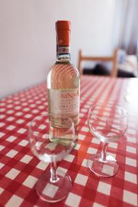 a bottle of wine sitting next to two glasses on a table at Apartament MonteCassino in Szczecin