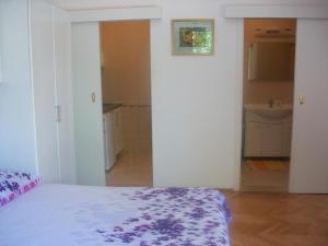 a white room with a bed and a bathroom at Studio Dominik in Makarska