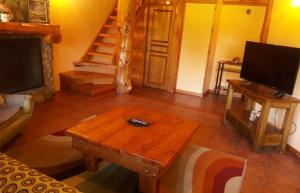 sala de estar con mesa de centro de madera y TV en Las Bahías en Villa La Angostura
