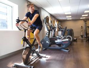 a man riding an exercise bike in a gym at M Social Hotel Times Square New York in New York