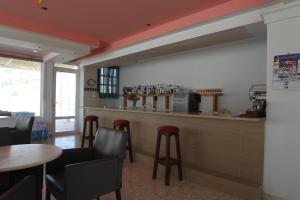 a restaurant with a bar with stools and tables at Antonis Hotel in Kefalos